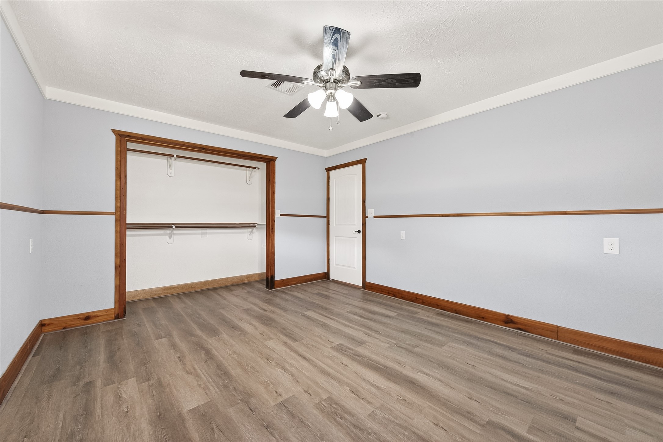 403 Wrangler Road Simonton, TX 77485 - Photo 20 of 33 an empty room with wooden floor chandelier fan and windows