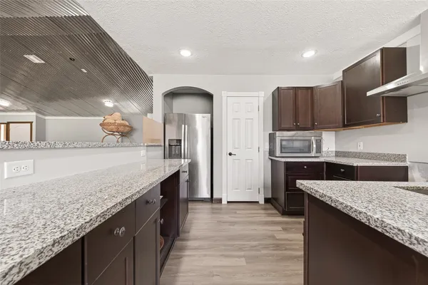 a kitchen with stainless steel appliances granite countertop a counter top a stove a sink and a refrigerator