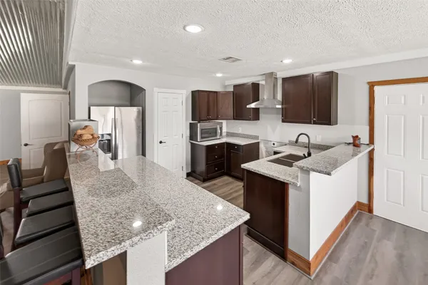 a kitchen with stainless steel appliances granite countertop a sink counter space and wooden floor