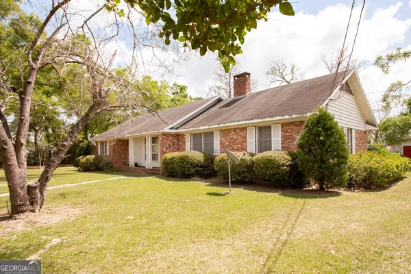 a front view of house with yard and trees around