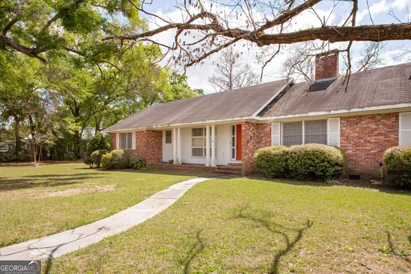 a view of a house with a yard and tree s