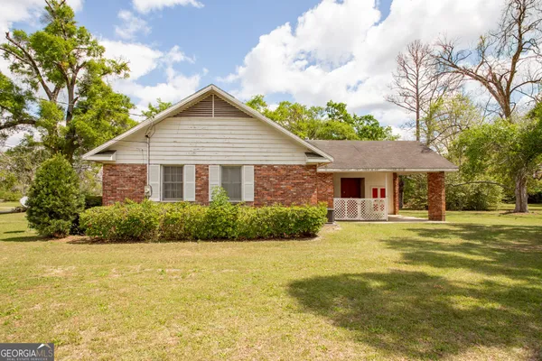 a front view of house with yard and trees