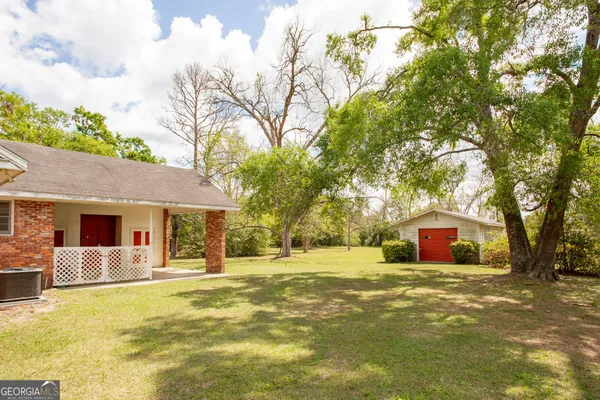 a front view of house with yard and trees in the background