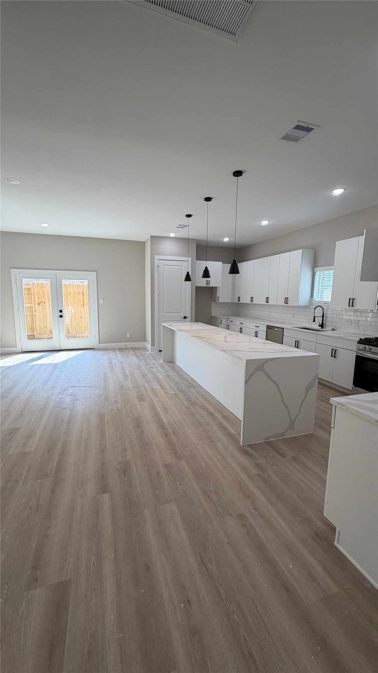 2607 Piemonte Avenue Cir Spring Spring, TX 77388 - Photo 12 of 38 a large white kitchen with kitchen island a sink dishwasher a stove and a refrigerator with wooden floor