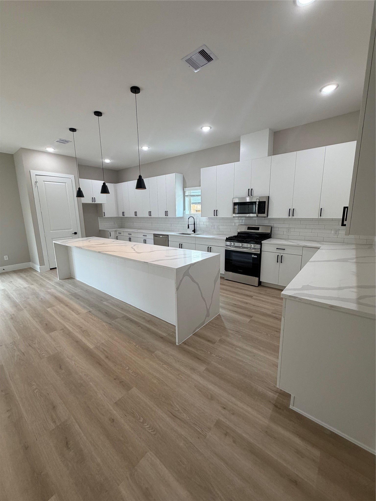 2607 Piemonte Avenue Cir Spring Spring, TX 77388 - Photo 18 of 38 a large white kitchen with kitchen island a sink a stove a refrigerator and white cabinets