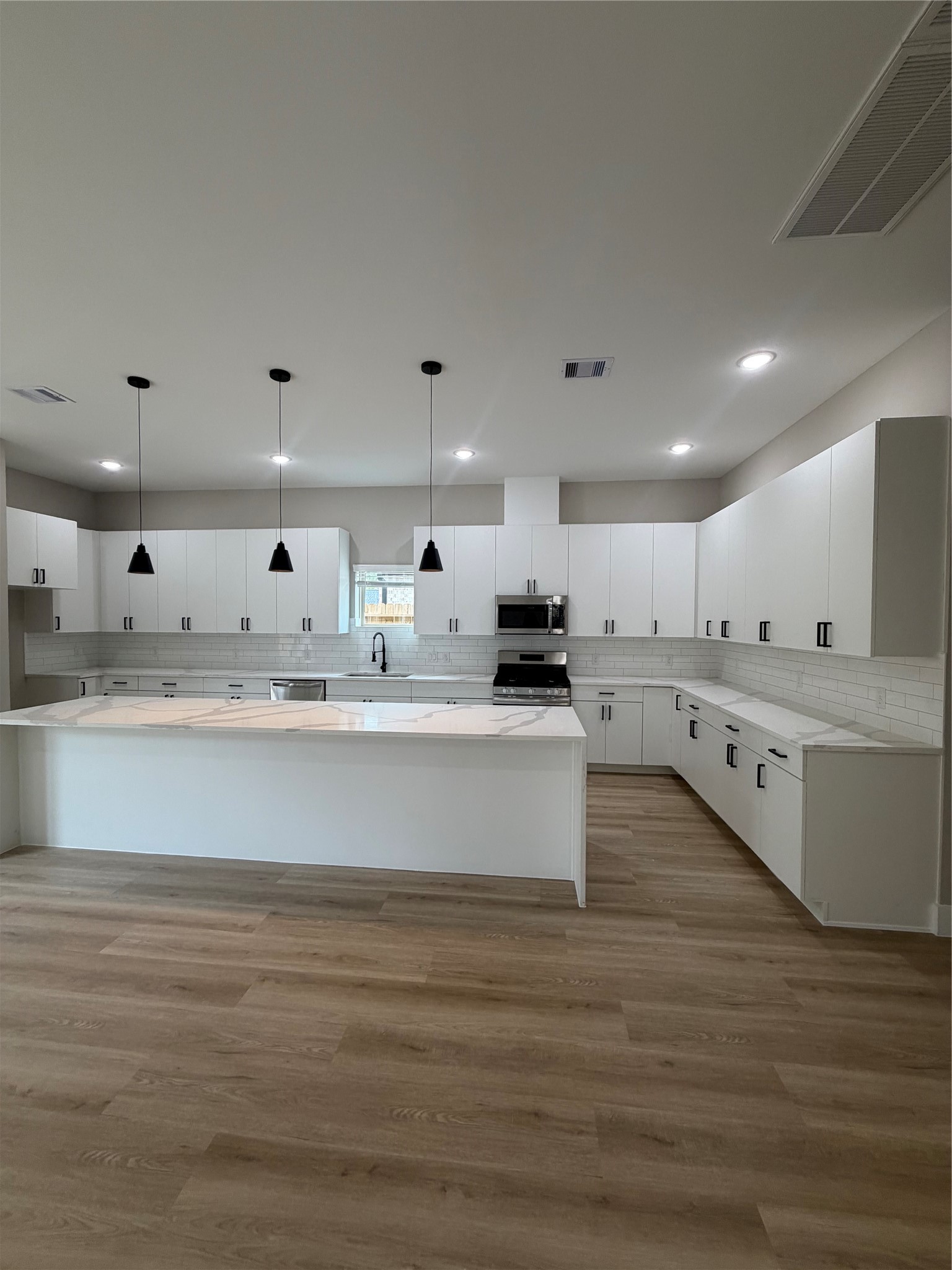 2607 Piemonte Avenue Cir Spring Spring, TX 77388 - Photo 19 of 38 a large white kitchen with kitchen island a sink stainless steel appliances and cabinets