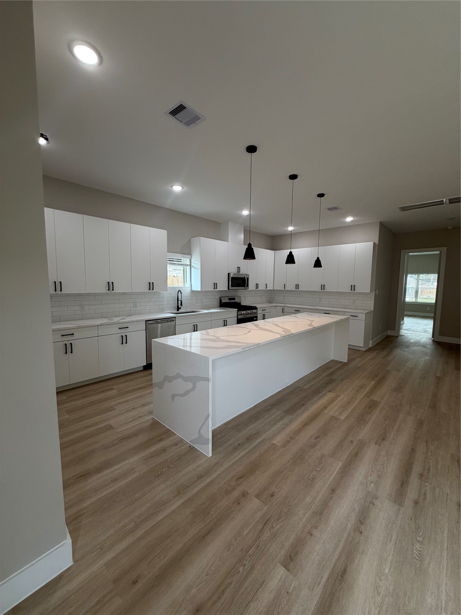 2607 Piemonte Avenue Cir Spring Spring, TX 77388 - Photo 20 of 38 a large white kitchen with kitchen island a sink stainless steel appliances and cabinets