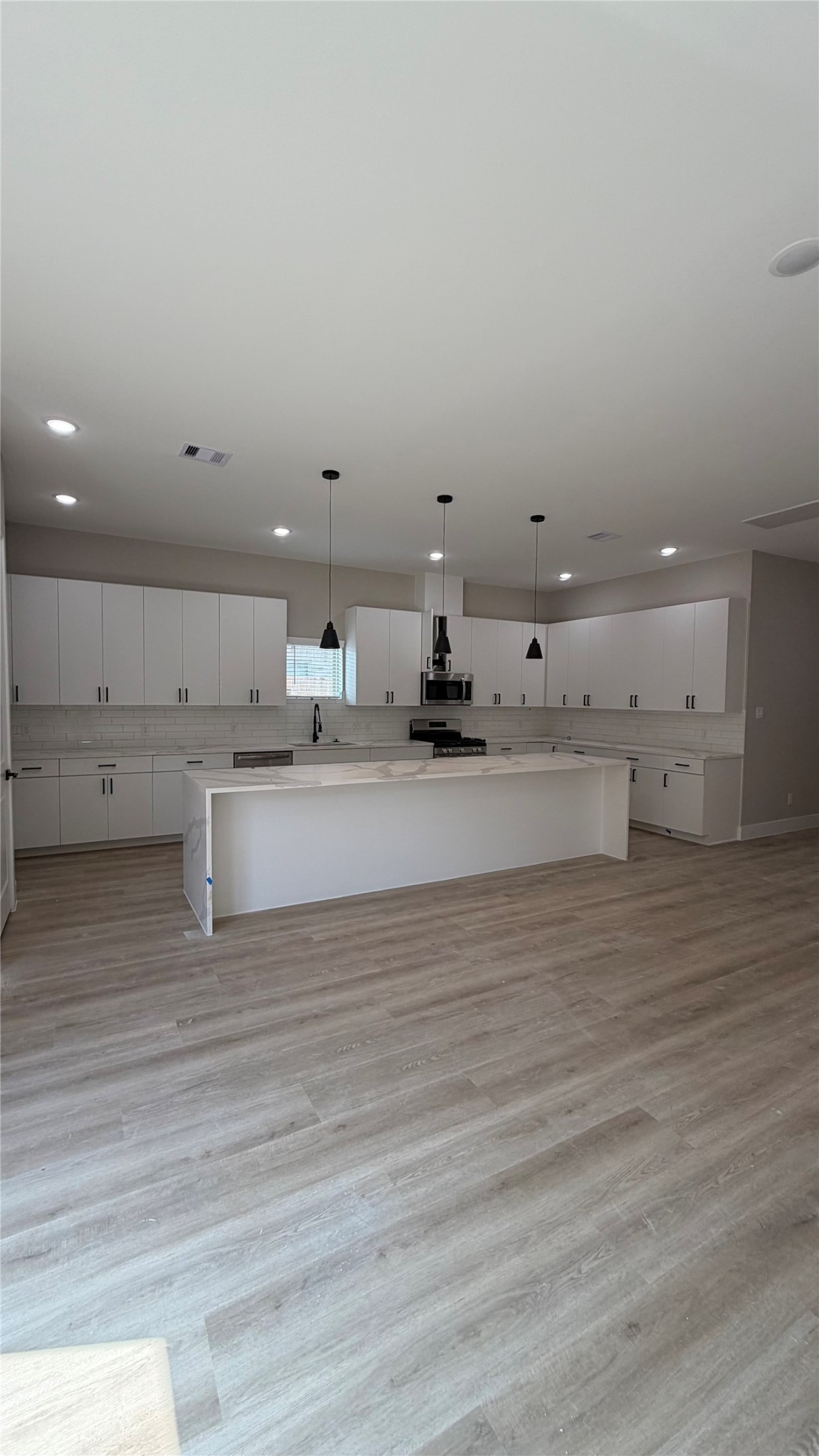 2607 Piemonte Avenue Cir Spring Spring, TX 77388 - Photo 3 of 38 a large white room with kitchen countertops and wooden floor