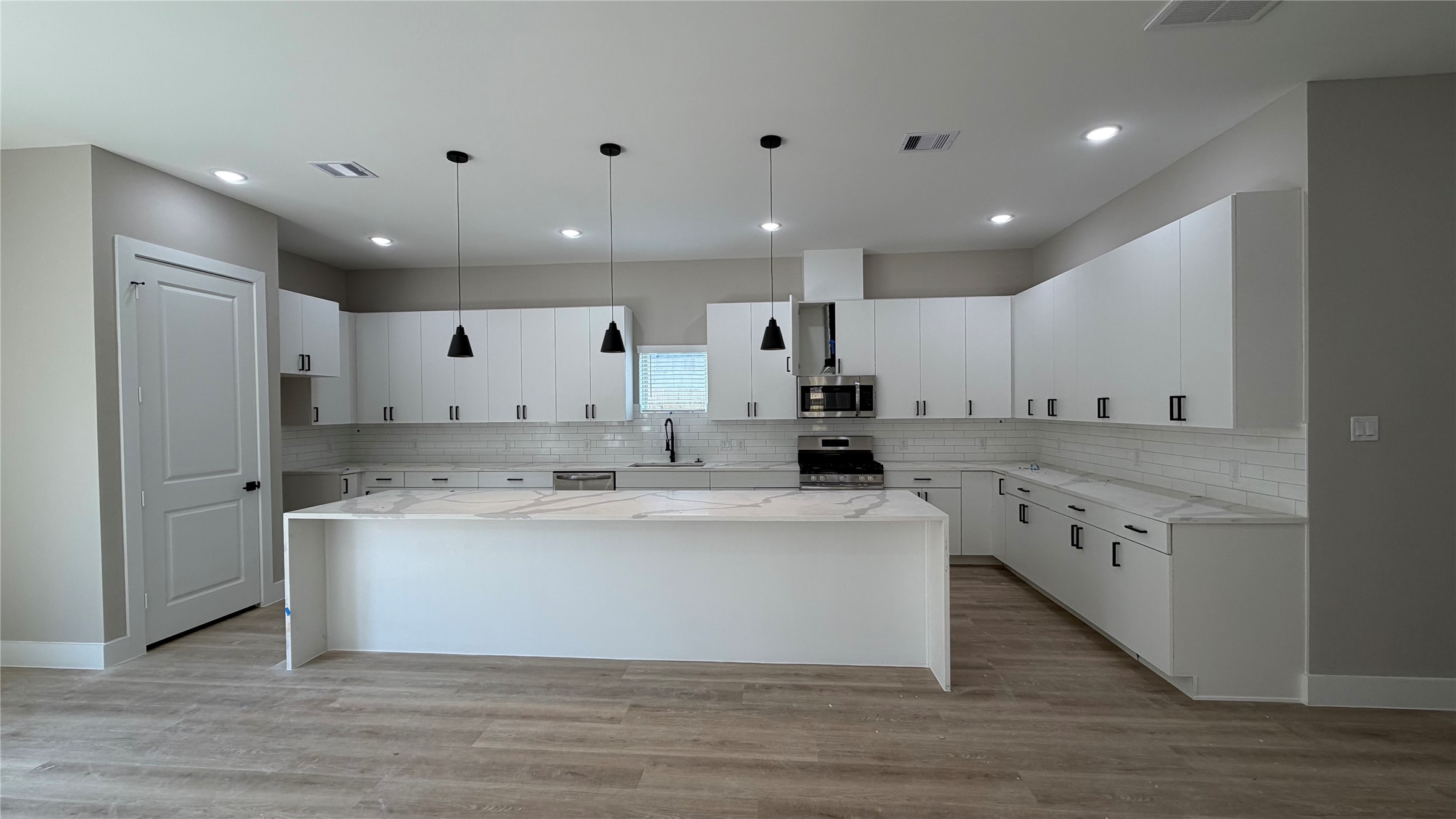 2607 Piemonte Avenue Cir Spring Spring, TX 77388 - Photo 6 of 38 a view of a kitchen with kitchen island a sink dishwasher stove with wooden floors