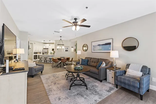 a living room with lots of furniture and view of kitchen
