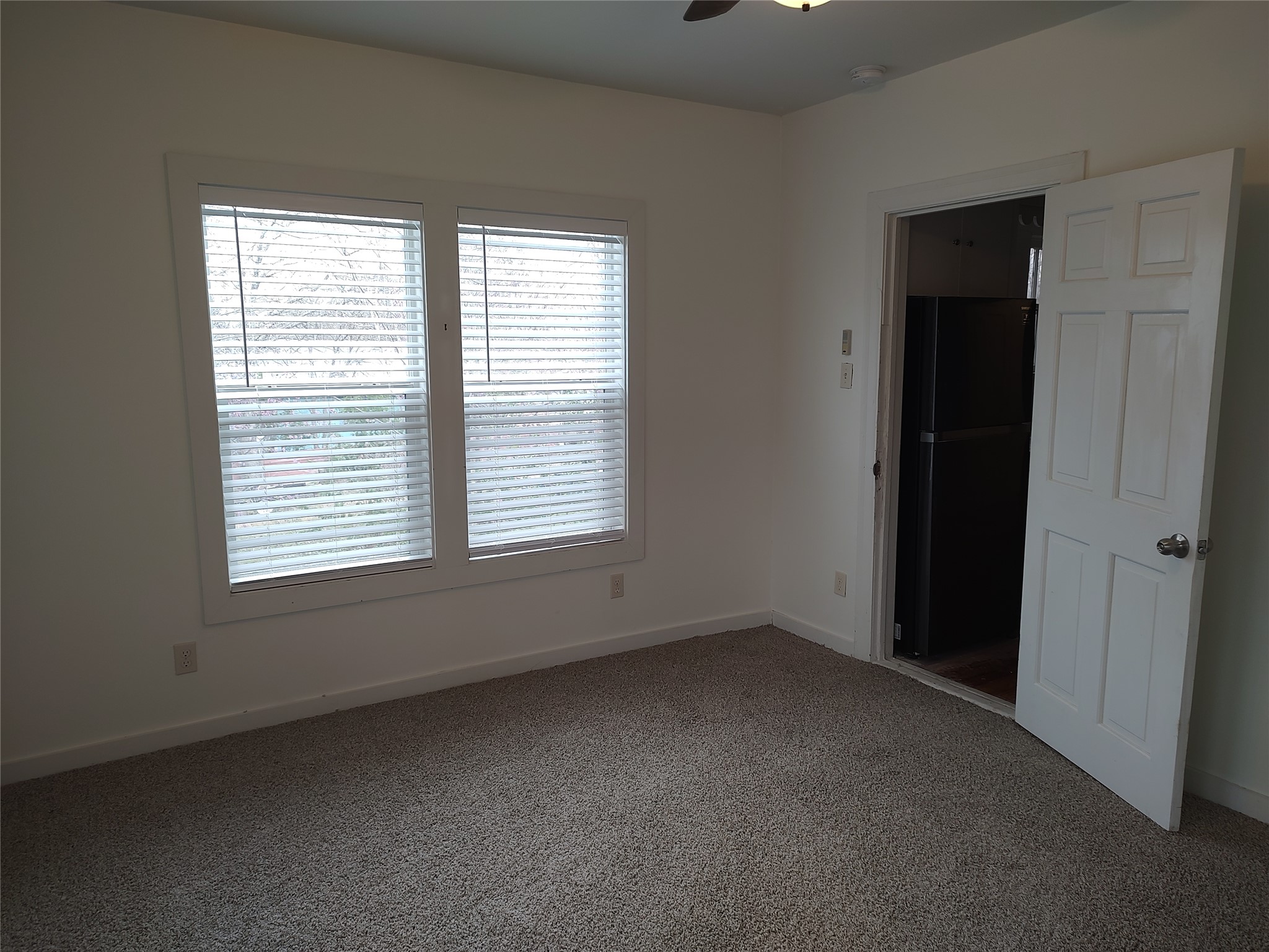 2102 Yellow Jacket Lane, Unit A Austin, TX 78741 - Photo 11 of 15 Unfurnished bedroom with freestanding refrigerator, carpet floors, and a ceiling fan