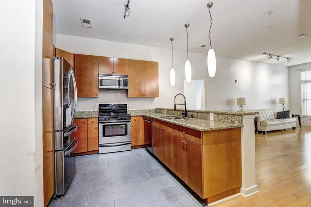 a kitchen with stainless steel appliances granite countertop a stove a sink a oven and a refrigerator