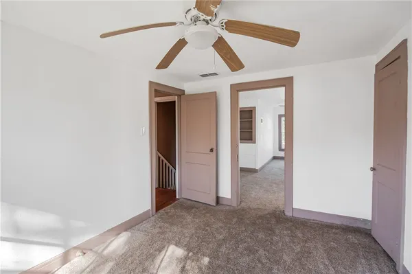 a view of a hallway with a chandelier fan