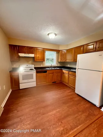 a kitchen with stainless steel appliances granite countertop a refrigerator a stove a sink and a microwave