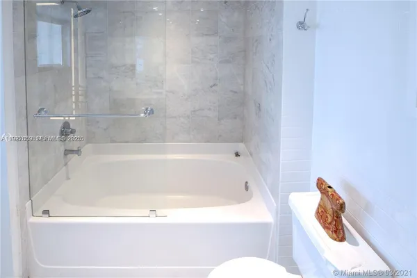 a white bath tub sitting next to a toilet