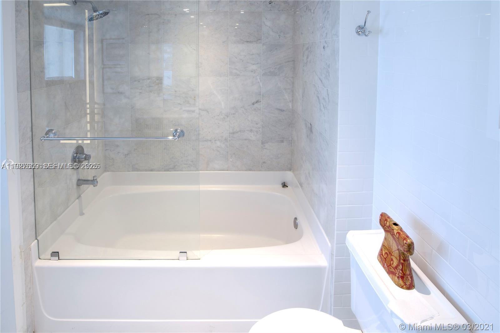 601 Northeast 36th Street, Unit 3101 Miami, FL 33137 - Photo 11 of 25 a white bath tub sitting next to a toilet