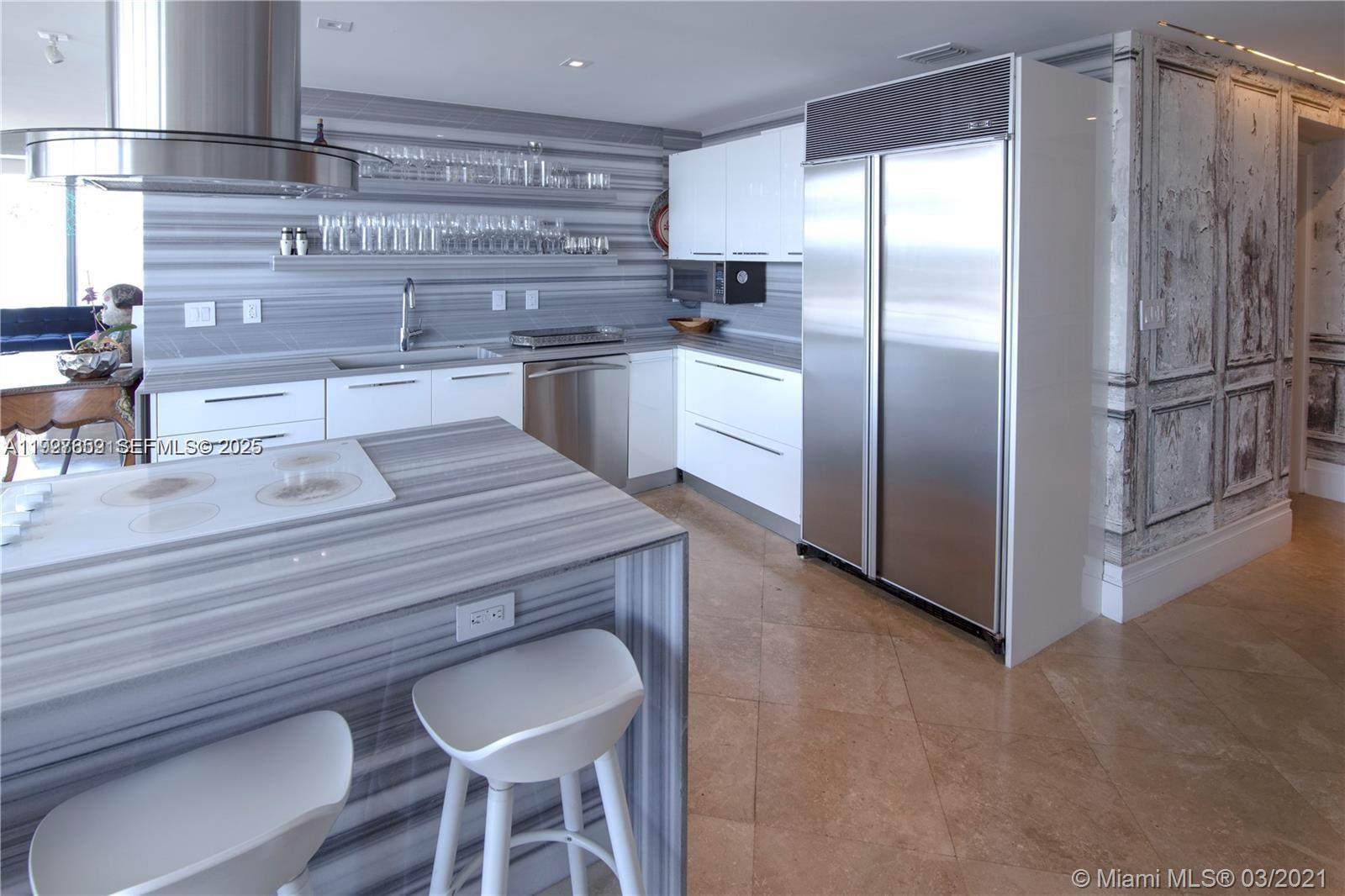 601 Northeast 36th Street, Unit 3101 Miami, FL 33137 - Photo 4 of 25 a kitchen with kitchen island a counter top space cabinets stainless steel appliances and cabinets