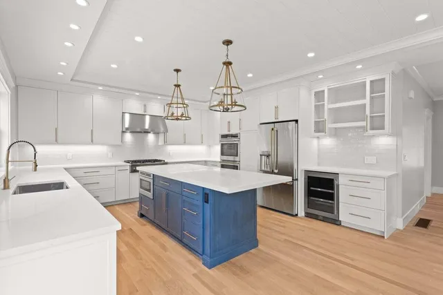 a kitchen with kitchen island a sink stainless steel appliances and cabinets