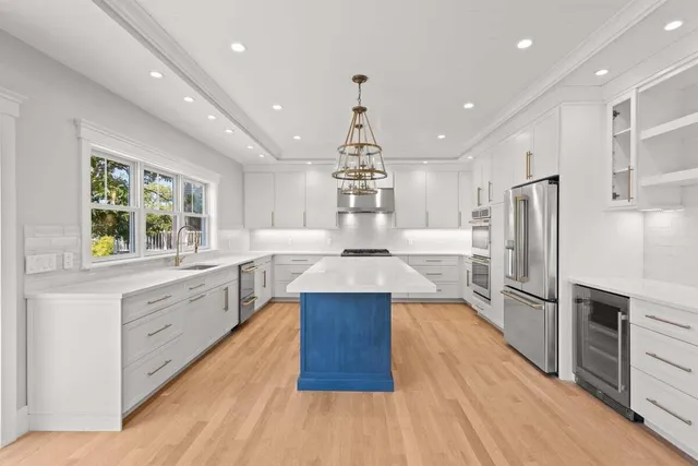 an open kitchen with wooden floor and stainless steel appliances