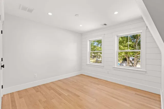 a view of empty room with wooden floor