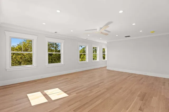 an empty room with windows and wooden floor