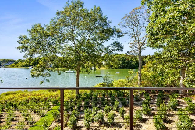 a front view of a house with garden and trees
