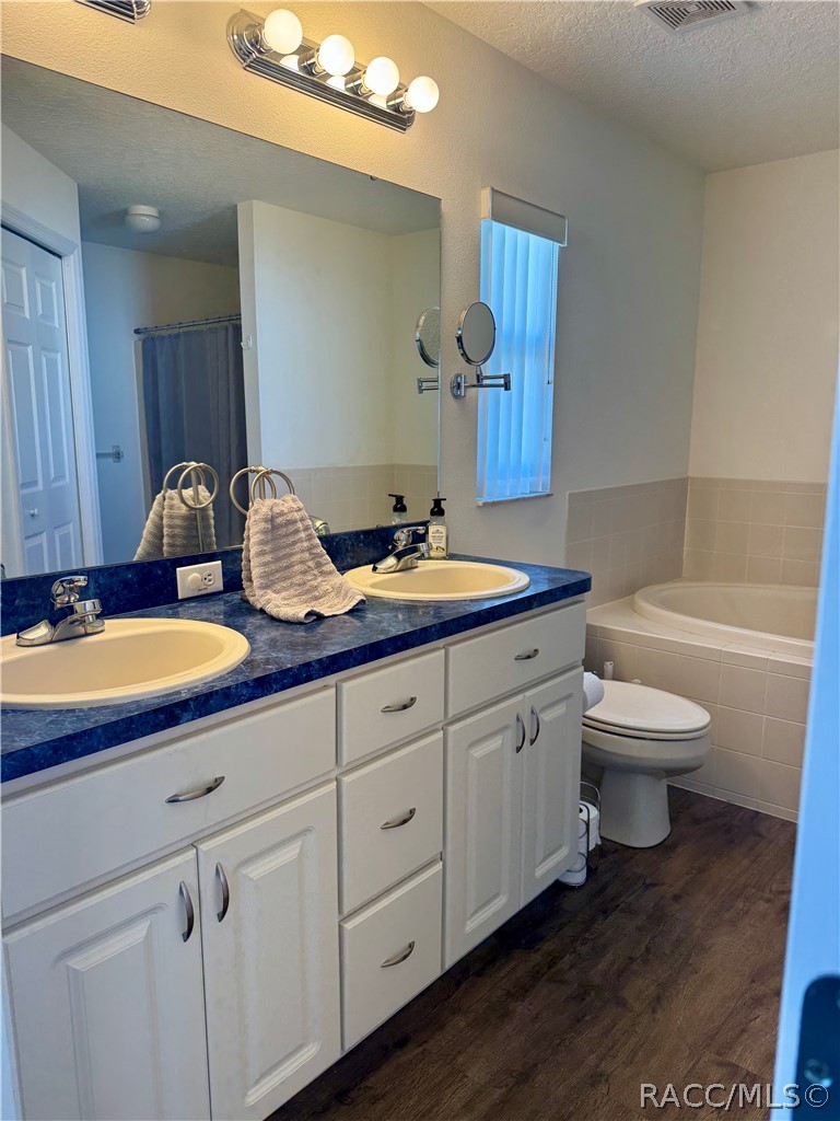 4588 East Van Ness Road Inverness, FL 34453 - Photo 18 of 34 a bathroom with a double vanity sink and a mirror