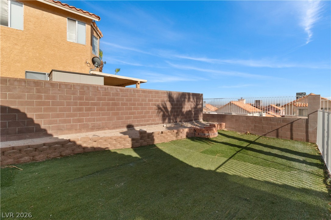 3156 Terrace View Drive Laughlin, NV 89029 - Photo 66 of 94 A low-maintenance yard with artificial turf and a private block wall offers serene outdoor living.