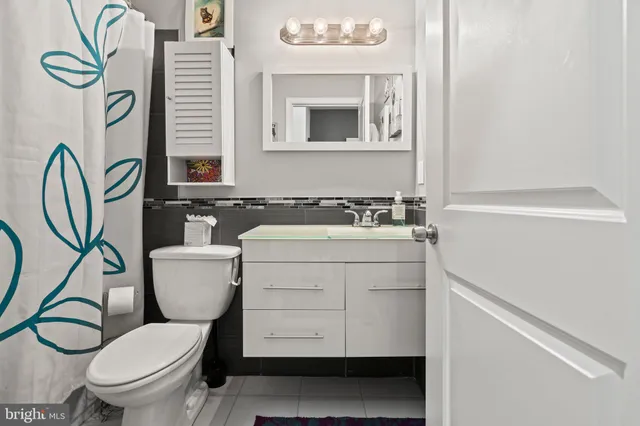 a bathroom with a granite countertop toilet sink and mirror