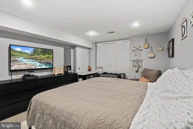 a spacious bedroom with a bed and a flat screen tv