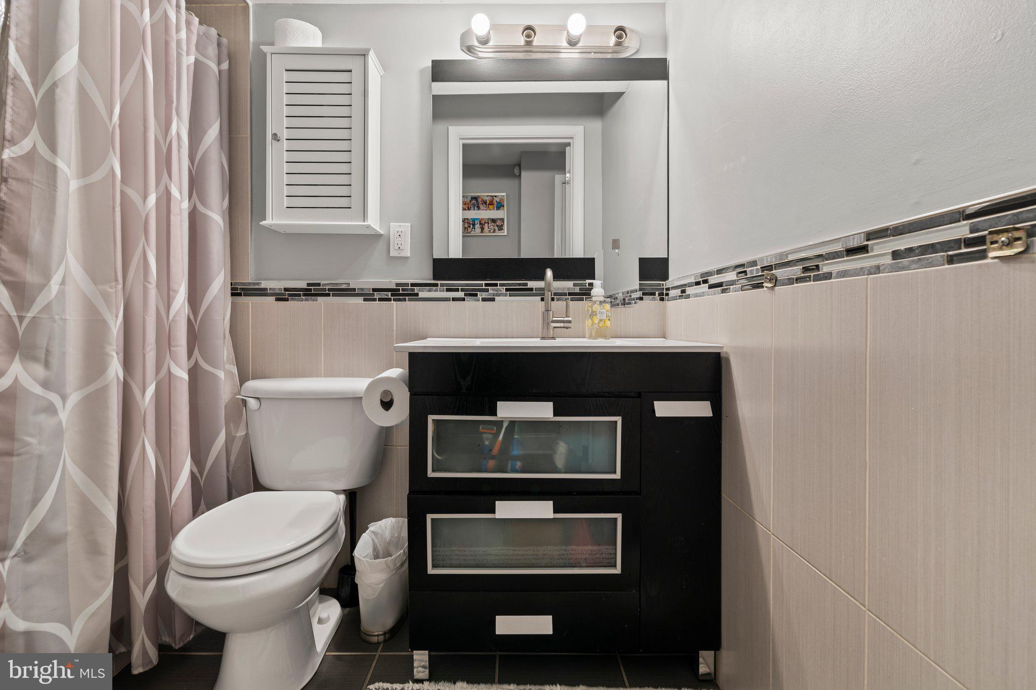 2115 Carpenter Street, Unit 1 Philadelphia, PA 19146 - Photo 23 of 24 a bathroom with a sink toilet and mirror
