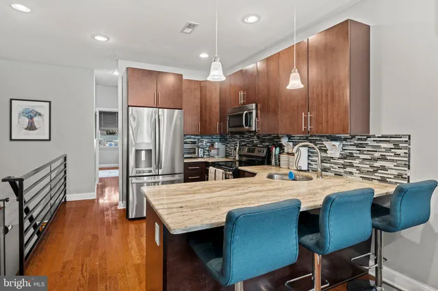 a kitchen with stainless steel appliances kitchen island granite countertop a kitchen island a stove a table and chairs