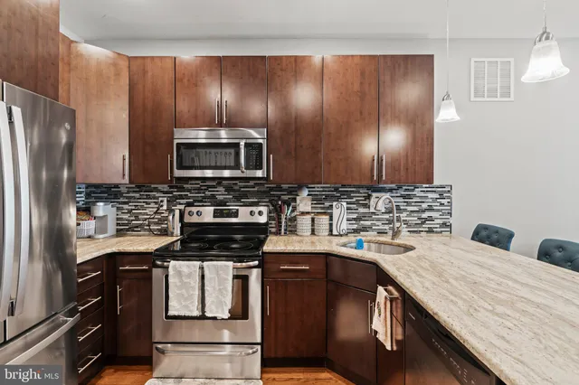 a kitchen with a sink stainless steel appliances and cabinets