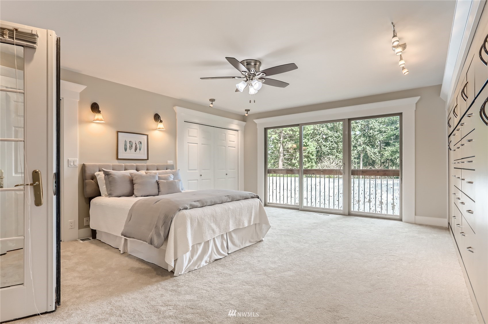 19810 43rd Avenue Southeast Bothell, WA 98012 - Photo 14 of 40 a spacious bedroom with a large bed and a chandelier fan