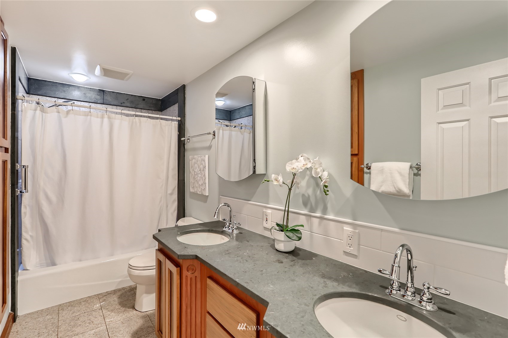 19810 43rd Avenue Southeast Bothell, WA 98012 - Photo 23 of 40 a bathroom with a granite countertop sink and a mirror