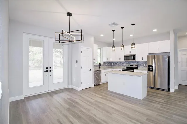 a kitchen with stainless steel appliances a refrigerator and a stove top oven