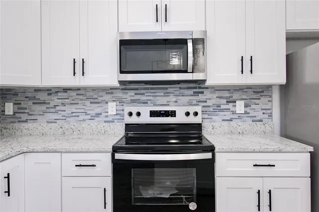 a kitchen with microwave cabinets and stove top oven