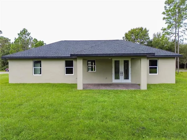an aerial view of a house with a garden and lake view
