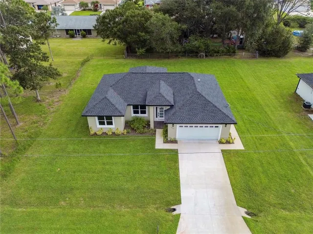 a aerial view of a house with swimming pool and a yard