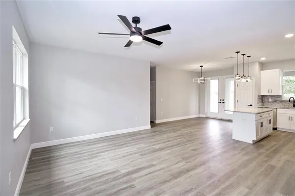 a view of an empty room and window and wooden floor