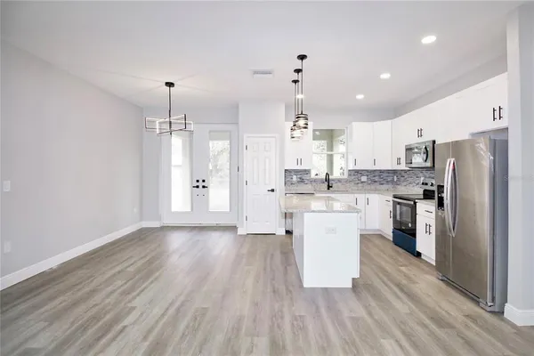a kitchen with a refrigerator and white cabinets