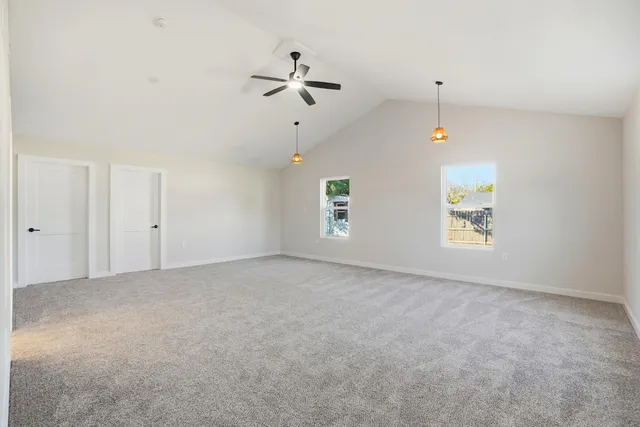 an empty room with windows and fan