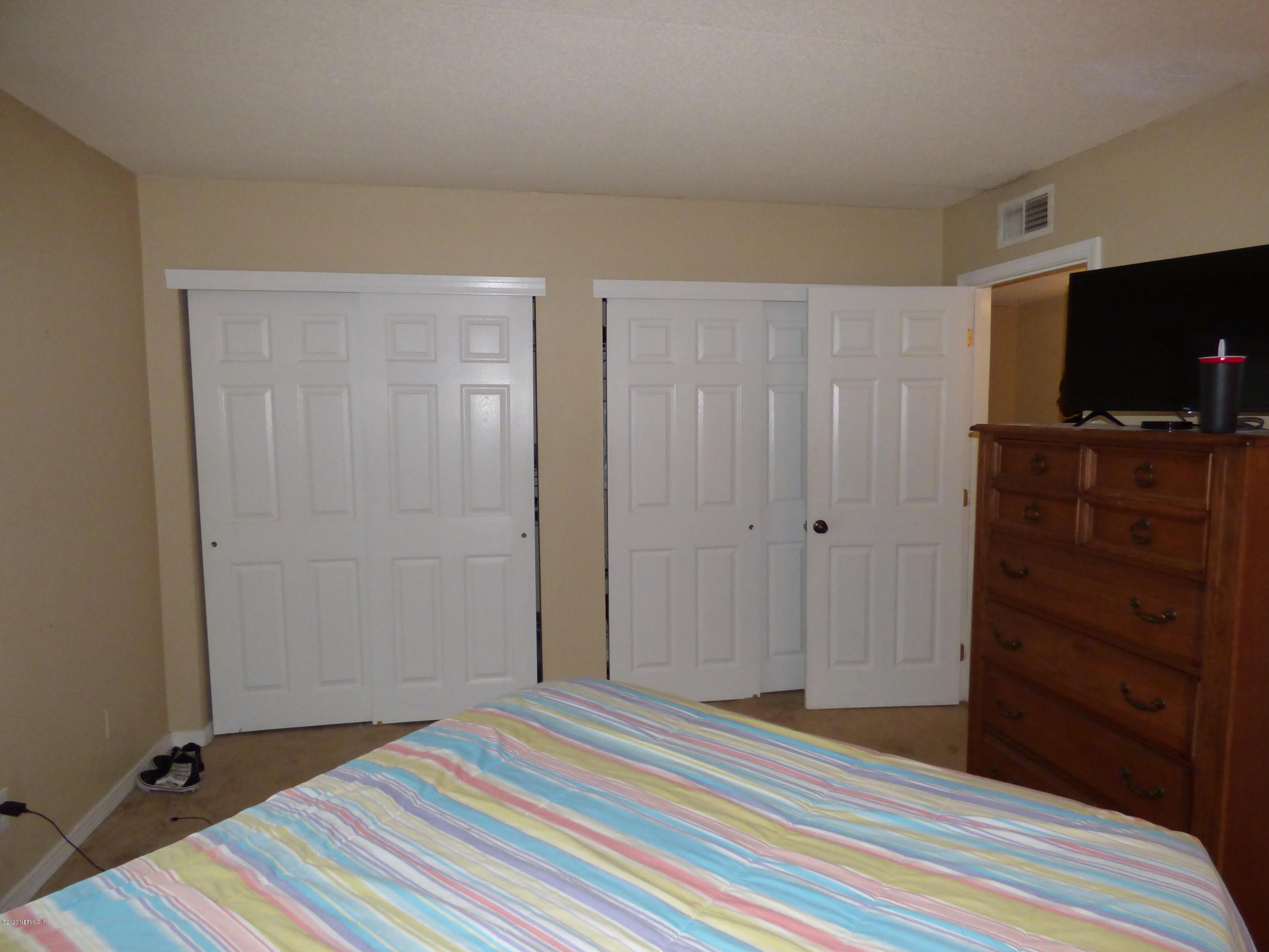 355 Monument Road, Unit 8 D2 Jacksonville, FL 32225 - Photo 11 of 19 a bedroom with a bed and flat screen tv