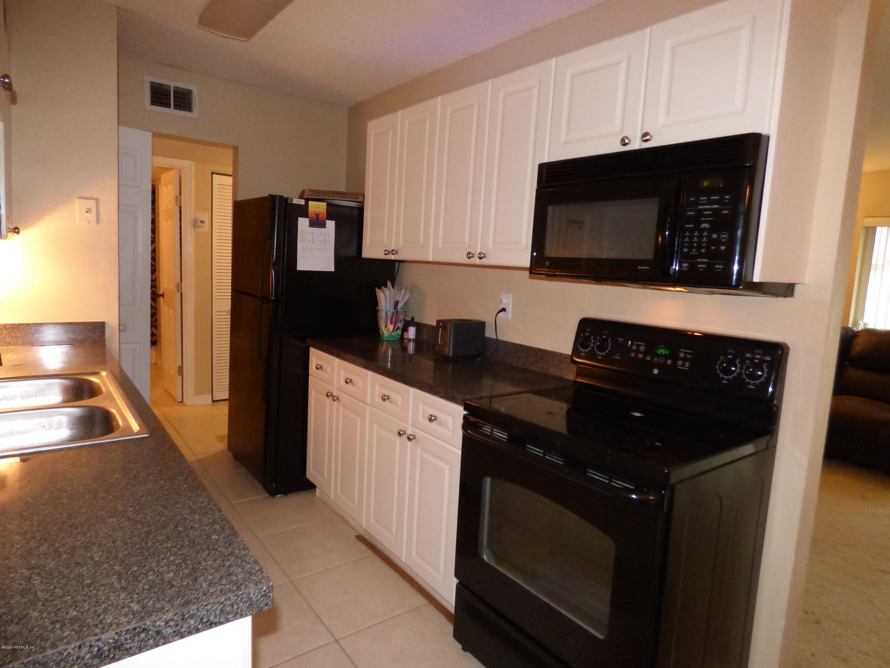 355 Monument Road, Unit 8 D2 Jacksonville, FL 32225 - Photo 6 of 19 a kitchen with stainless steel appliances a stove a microwave a sink and cabinets