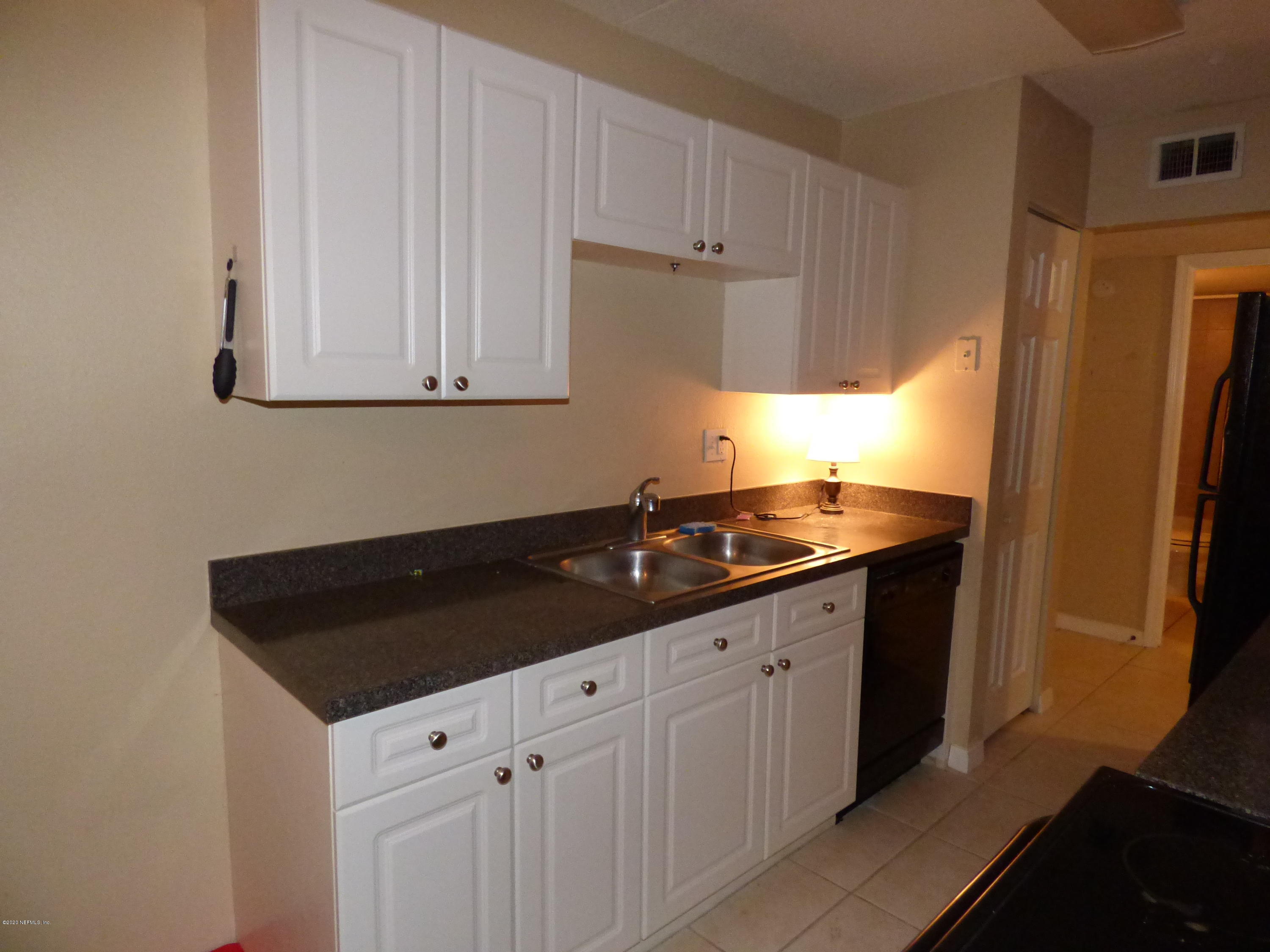 355 Monument Road, Unit 8 D2 Jacksonville, FL 32225 - Photo 7 of 19 a kitchen with granite countertop white cabinets and a sink
