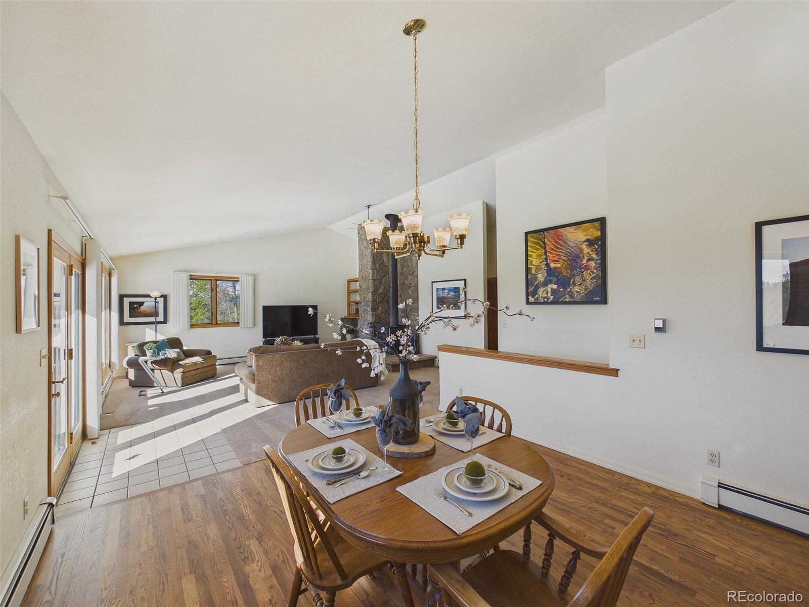 10798 Crystal Way Morrison, CO 80465 - Photo 11 of 36 a view of a dining room with furniture a chandelier and wooden floor