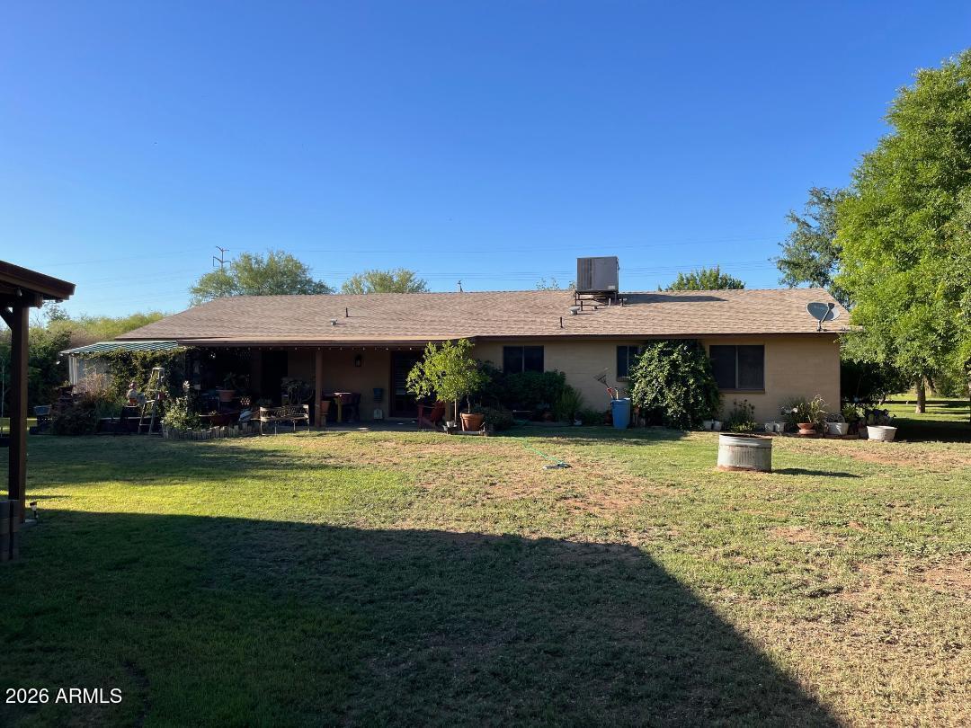 9115 West Broadway Road Tolleson, AZ 85353 - Photo 2 of 13 a front view of a house with a garden and swimming pool