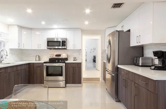 a kitchen with stainless steel appliances a refrigerator a sink a stove and cabinets