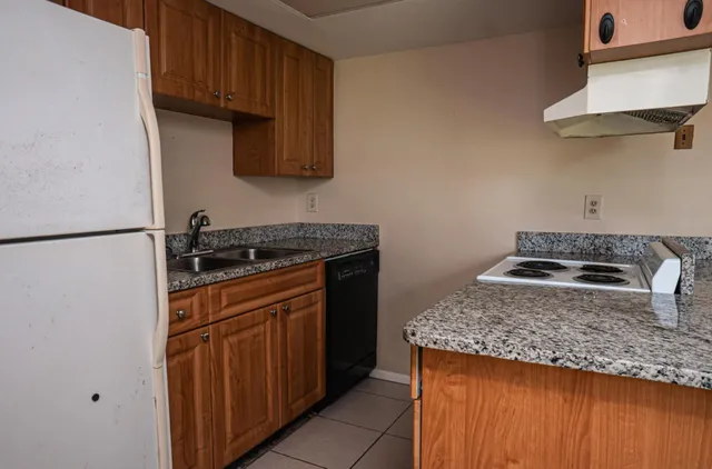 a kitchen with granite countertop a sink stove and cabinets