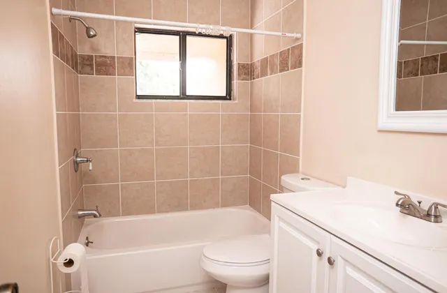 a bathroom with a bathtub sink vanity mirror and toilet